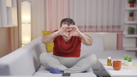 Man-making-heart-symbol-for-camera.